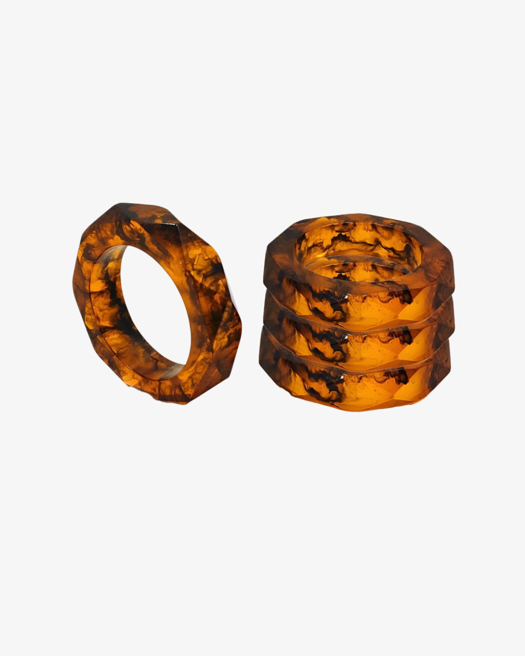 A set of translucent, geometric napkin rings from the Prism Collection in a Tortoise pattern