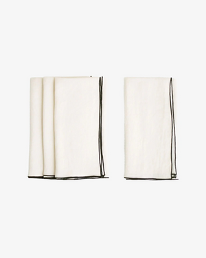 Cathedral stone washed linen napkin in ivory with black surged stitch edge, set of 4